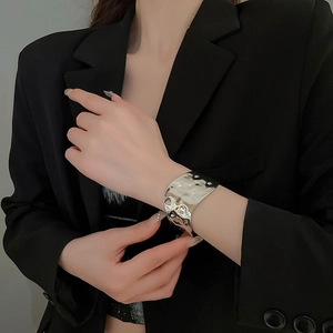 Detail of wide silver hammered metal cuff bracelet with unique mirror light reflection