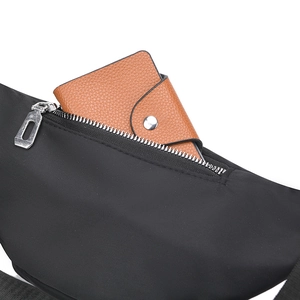 Detail showing high-capacity nylon chest bag with zippers and leather wallet storage