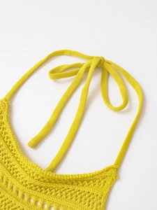 Detail of bright yellow crochet halter top showing textured knit and adjustable neck ties