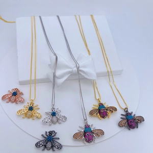 Collane con ciondolo a ape in oro e argento con zirconi colorati su espositore bianco