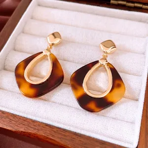 Boucles d'oreilles pendantes géométriques en résine écaillée et métal doré