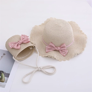Detail of girls' straw hat and matching bag with pink bow and pearl accents