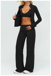 Three-piece black yoga set with zip-up jacket, sports bra, and flared leggings detail