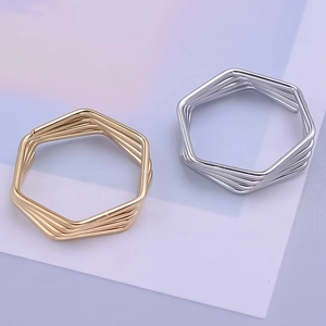 Detail of minimalist 304 stainless steel hexagonal wire wrap rings in gold and silver