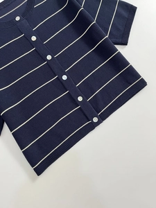 Detailed knit texture of navy striped cardigan featuring white pearlescent buttons