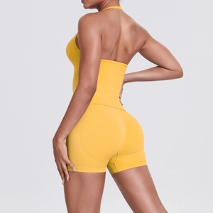 Detail of yellow halter yoga top and high waist shorts showing lifting effect on model