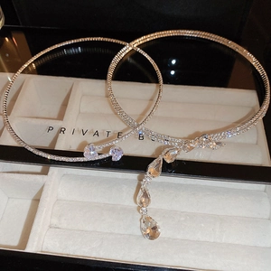 Detail of silver double layer necklace with heart and drop zircon pendant in a beige box