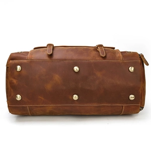 Detail view of the travel bag base with six metal feet and contrast stitching