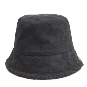 Detail of black faux suede bucket hat featuring plush lamb wool trim and small leather label