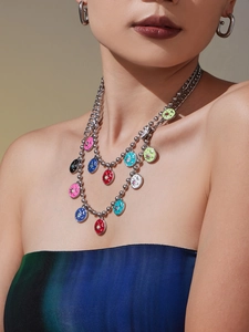 Close-up of double layered stainless steel necklace with colorful enamel astral charms