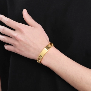 Close-up of a sleek gold curved bar bracelet on wrist with elegant link chain