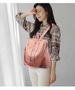 Modern pink water-resistant nylon backpack for women shown in a bright indoor setting