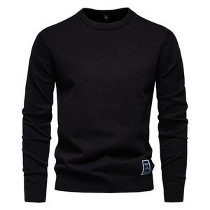 Détail du col et de la texture d'un pull en maille noire pour homme d'automne hiver