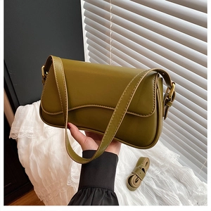 Detail of olive green baguette bag featuring gold hardware and elegant shoulder strap