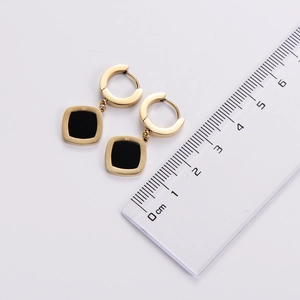 Detail view of square gold earrings with black inlay and roman numerals measuring 1.3 cm
