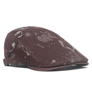 Detail view of brown vintage flat cap with white graffiti print and metal buckle adjustment