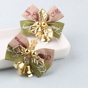 Detail of plush Christmas bows with golden bells, leaves and Merry Christmas print