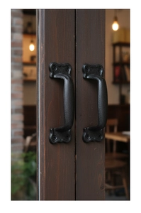 Macro view of vintage black cast iron door handles with a matte grainy texture