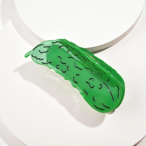 Detail of vibrant green cucumber shaped acetate hair claw clip with black wavy texture