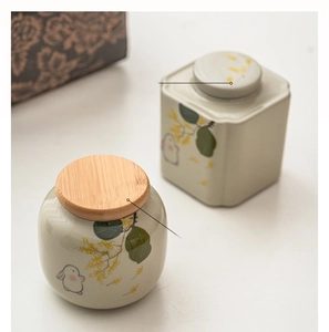 Detail of round and square ceramic tea canisters with hand-painted rabbit and plum patterns