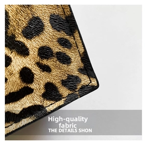 Detailed close-up of premium leopard print leather texture and precise black stitching