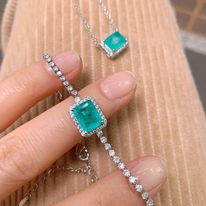 Elegant emerald silver jewelry set featuring a rectangular pendant necklace and bracelet