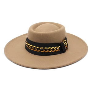 Detail of camel wool fedora hat featuring a wide brim and decorative chunky gold chain