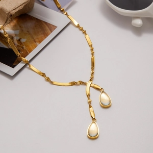 Detail of 18K gold stainless steel necklace with green teardrop pendants on a white background