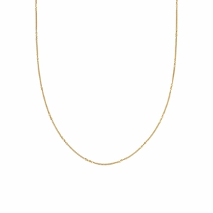 Detail of multi-layer gold chain necklace with gemstone in Maillard aesthetic