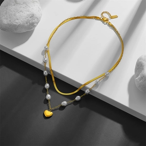 Double-layered gold necklace featuring pearl accents and heart pendant on flat snake chain