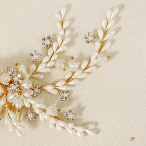 Close-up of bridal hair comb with gold wire, pearls, and rhinestones in floral design