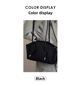 Detail view of black glossy shoulder bag with knot straps and silver hardware accents