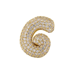 Macro shot of gold-plated cubic zirconia pavé puffy letter G pendant with clear crystals