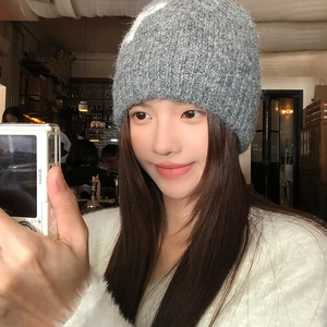 Detail of grey chunky knit beanie showing soft mohair texture in a warm indoor setting