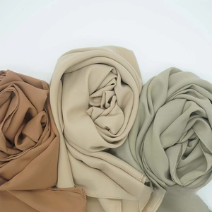 Detail showing high-quality satin chiffon scarves in brown, beige, and green draped in floral folds