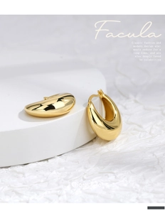Close-up of gold-plated chunky C-shape hoop earrings with a polished mirror finish