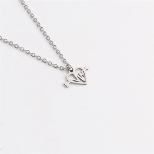 Detail shot of silver stainless steel heart necklace with heartbeat line and arrow design