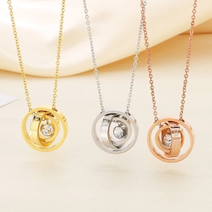 Macro detail of triple-ring pendant necklaces with zircon inlay and engraved love quotes