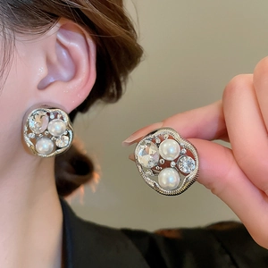 Detail of silver drop earrings featuring irregular pearls and sparkling rhinestones