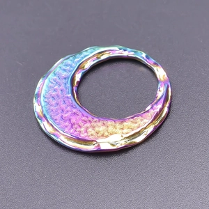 Detailed shot of an irregular metal ring with rainbow plating and hammered texture