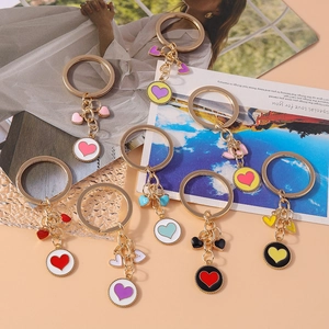Set of eight colorful heart-shaped enamel keychains with golden metal round pendants