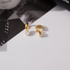 Detailed close-up of 18K gold stainless steel earrings with sparkling white cubic zirconia