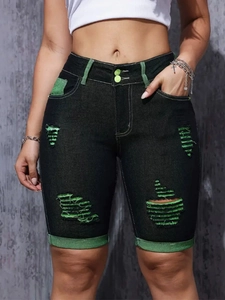 Detailansicht der schwarzen Denim-Shorts mit grünem Futter und Doppelknopf-Verschluss