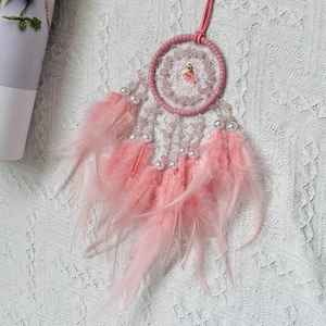 Pink dream catcher car hanging ornament with feathers and crystal stones on white fabric