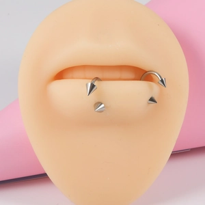 G23 titanium circular lip rings with spike studs shown on a silicone mouth model