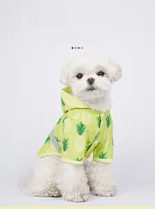 Waterproof light green pet raincoat with white pineapple print and reflective strip detail