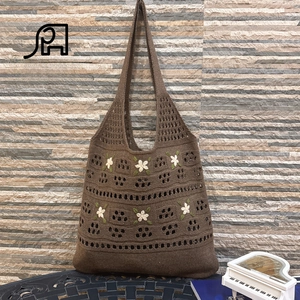 Detailed view of the handmade crochet tote bag featuring 3D white flower embroidery texture