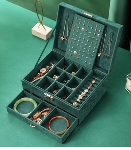Macro view of dark green velvet jewelry box with multi-layer storage and metal drawer handle