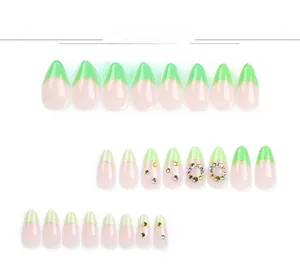 Detail view of French green almond press-on nails with colorful rhinestone embellishments