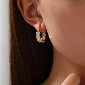 Elegant 18k gold plated hoop earrings with full pave cubic zirconia worn by a model